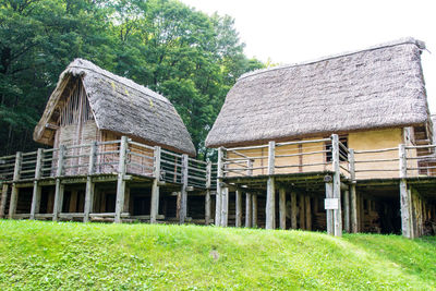 House on field against trees and houses