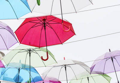 Low angle view of umbrellas hanging against sky