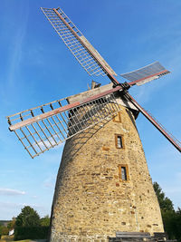 Low angle view of traditional windmill against sky