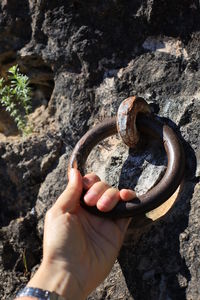 Close-up of hand holding ring in s rock