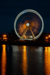 Low angle view of illuminated ferris wheel at night