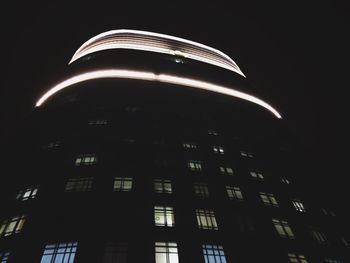 Low angle view of illuminated building against sky at night