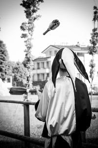 Rear view of man juggling bottles