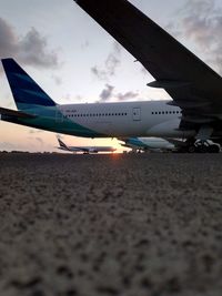 Airplane on airport runway against sky