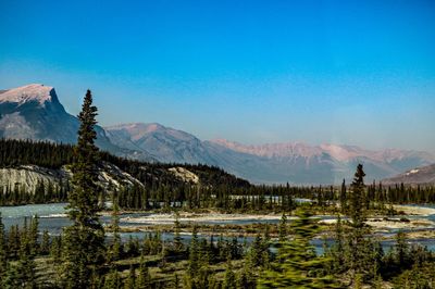 Scenic view of lake and mountains against blue sky