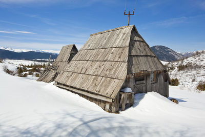 Built structure on snow covered mountain against sky