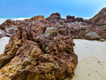 Rock formation on beach against clear sky