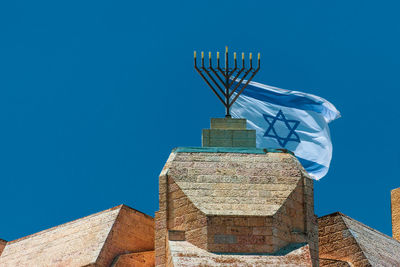 The menorah and the national flag of israel on the city walls in jerusalem