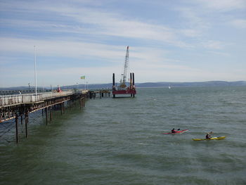 People in boat on sea against sky