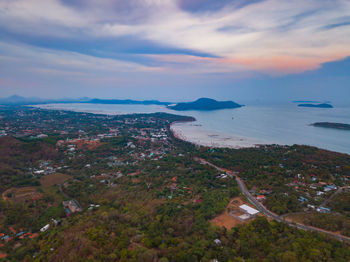 Aerial view of sea and cityscape against sky