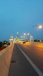 Empty road along buildings at night