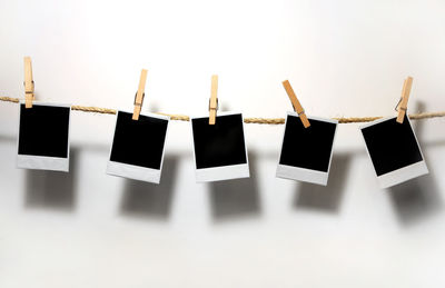 Close-up of clothes drying on clothesline against white background