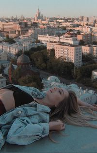 High angle view of woman lying on terrace against cityscape