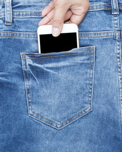 Cropped hand putting mobile phone in pocket