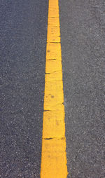 High angle view of yellow arrow symbol on road in city