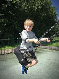 Portrait of cute boy playing with arms raised