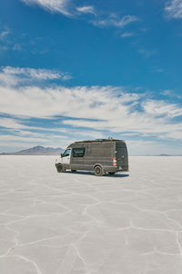 Camper van on bonneville salt flats in utah during a summer road trip.