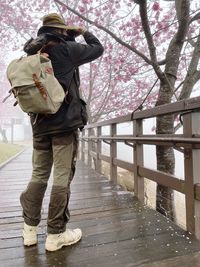 Low section of man standing on railing