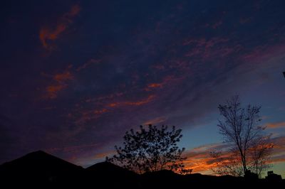 Low angle view of silhouette trees against sky at sunset