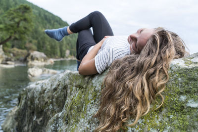 Teenage girl laying on rock at clayton beach