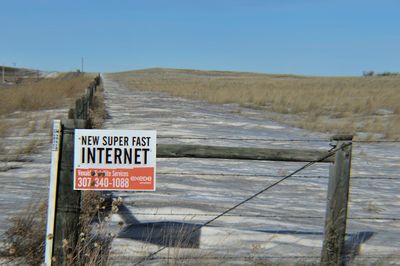 Advertisement board on barbed wire at snow covered field