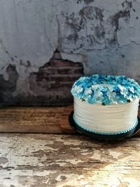 Close-up of cake on table against wall