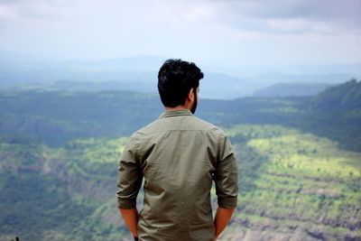 Rear view of man looking at mountains