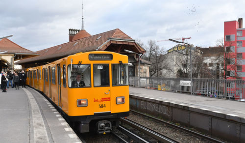 Train at railroad station in city against sky