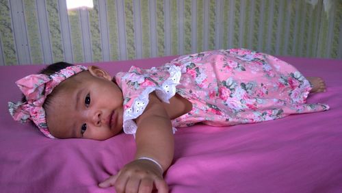 Portrait of cute girl lying on bed
