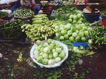 Midsection of vendor with various vegetables for sale at market