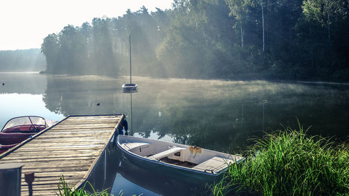 Boats moored on lake against sky