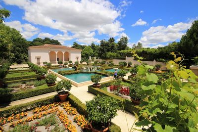 Panoramic view of swimming pool by building against sky