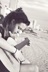 Young woman playing guitar at beach