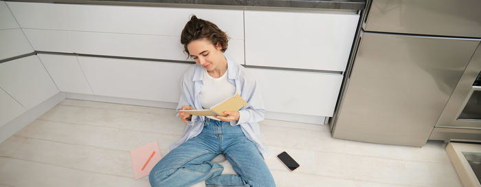 Portrait of young woman standing on floor