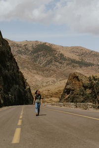 Rear view of man on road against sky