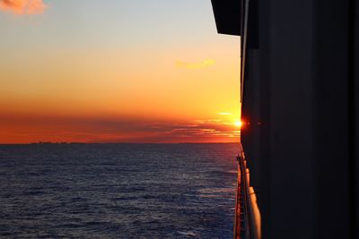 Silhouette boat sailing in sea against sky during sunset