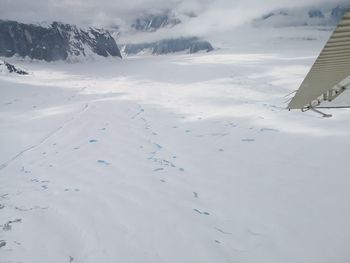 Aerial view of snowcapped landscape against sky