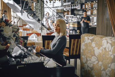Portrait of a smiling young woman sitting at table