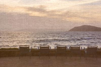 Chairs on beach against sky