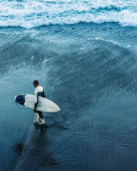 Rear view of man surfing in sea