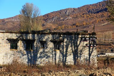 Built structure on field against mountain