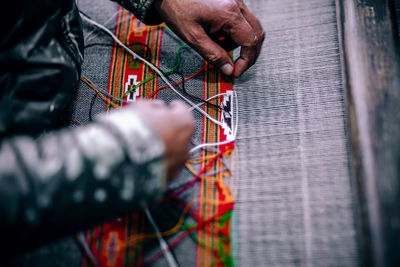 Midsection of person knitting textile in factory