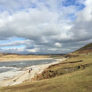 Scenic view of beach against cloudy sky