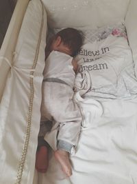 High angle view of baby sleeping in crib