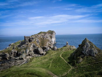 Rock formations by sea against sky