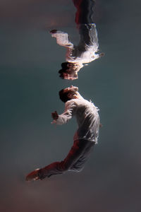 Underwater photo of a man in a shirt and trousers. ballet dancer underwater