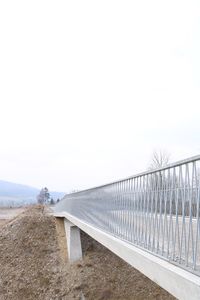 Railing on bridge against clear sky