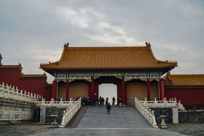 Group of people outside temple against sky