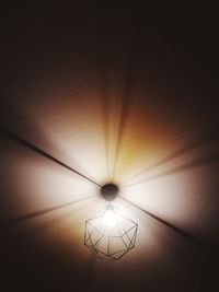 Low angle view of illuminated pendant lights hanging from ceiling