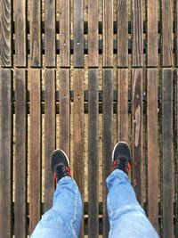 Low section of man standing on wooden floor